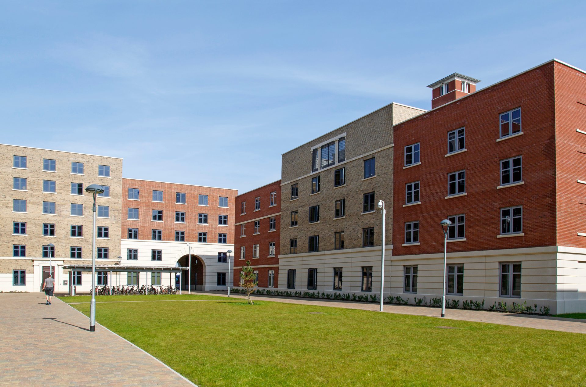 Modern multi-block PBSA student accommodation complex in red and pale brick, with a paved courtyard
